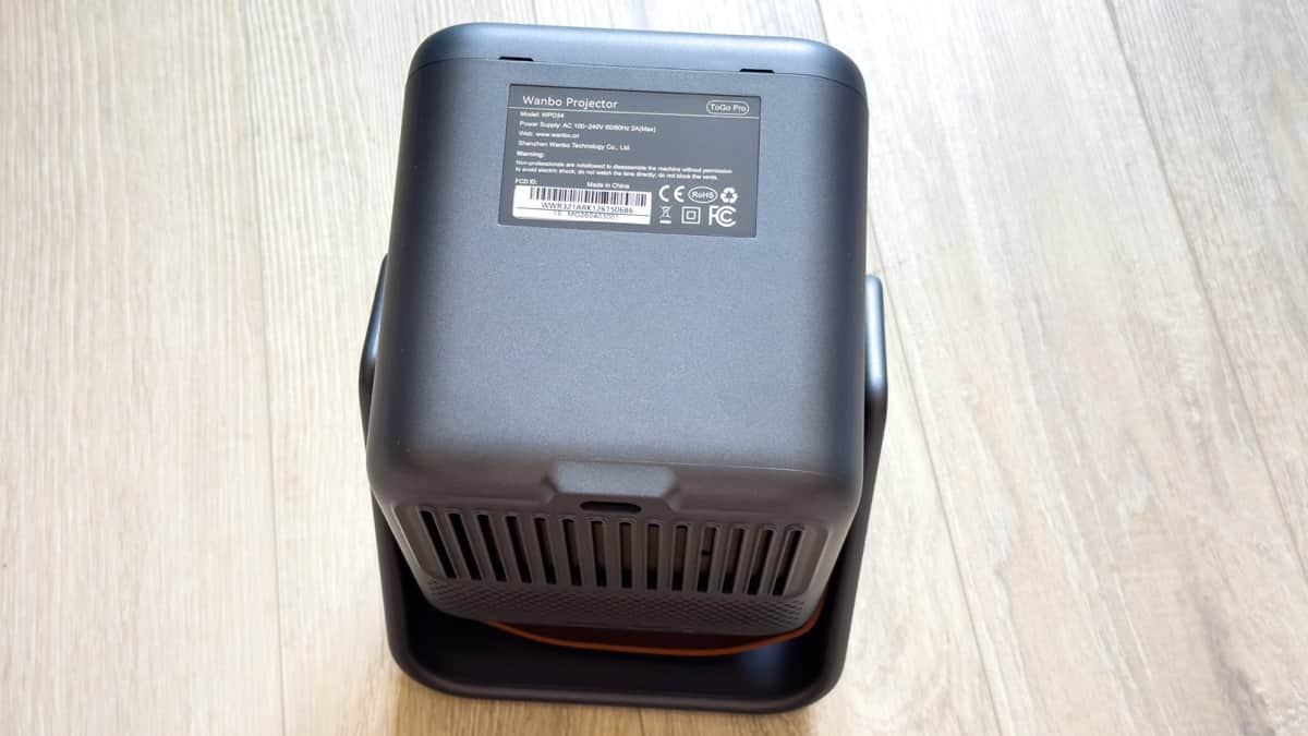 Regulatory label on the projector underside confirming model WPD34, 100-240V AC power, and CE, FCC, RoHS compliance certifications