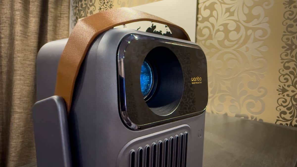 Wanbo ToGo Pro portable smart projector front view featuring illuminated blue lens, gold logo, and leather carrying strap