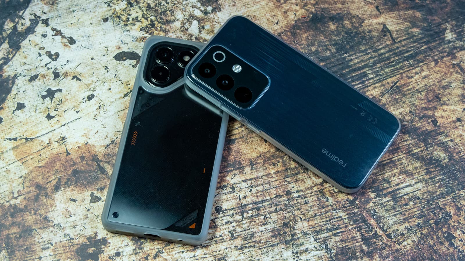 Front displays of the realme P4 and TECNO POVA 7 Neo illuminated on a desk — Photo: Sergey Kuznetsov