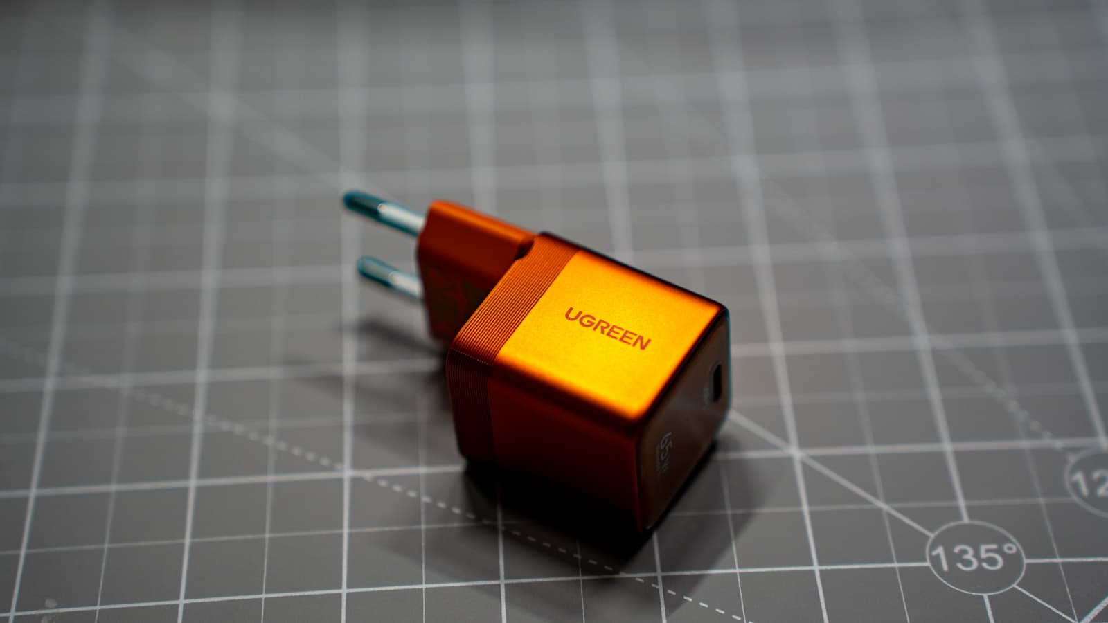 Side profile of the metallic orange chassis with UGREEN branding and ribbed grip — Photo: Sergey Kuznetsov