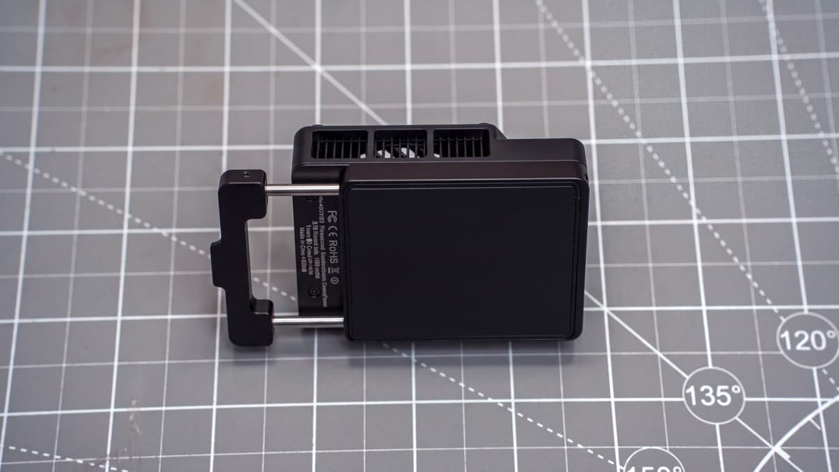 Underside of the cooler showing smooth Peltier contact plate, extended sliding clamp, and FCC/CE markings