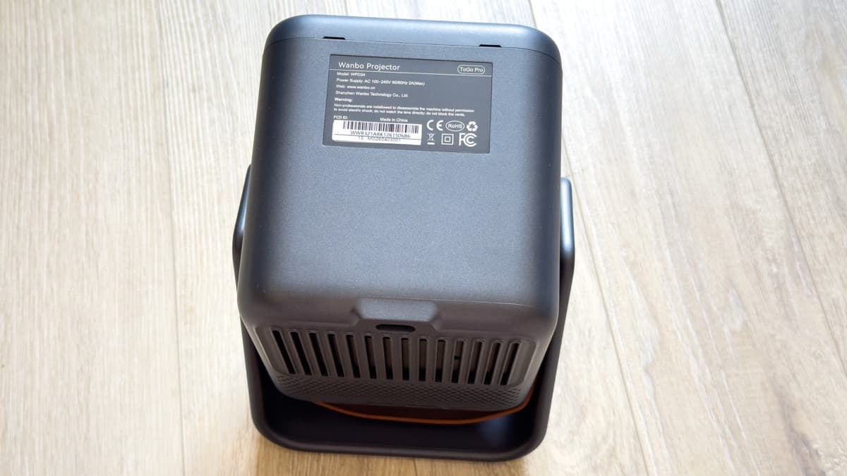 Regulatory label on the projector underside confirming model WPD34, 100-240V AC power, and CE, FCC, RoHS compliance certifications